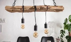 Drewniany żyrandol diy z trzema żarówkami w stylu industrialnym, wiszący na łańcuchach nad stołem.