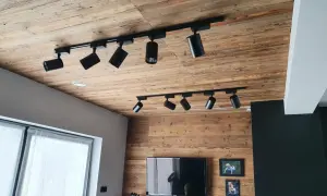Drewniany sufit z szynoprzewodami i reflektorami to świetny pomysł na sufit w pokoju.