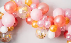 Ładna girlanda z balonów w odcieniach różu, brzoskwini i złota. Zobacz, jak zamocować balony na taśmie, by stworzyć efektowną dekorację.