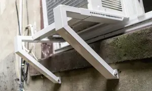 Solidne oparcie dla ramy okiennej, wykonane z białego metalu, zapewnia stabilne mocowanie klimatyzatora.
