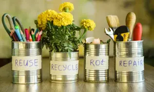 Puszki metalowe pokazują, co zrobić z odpadami: REUSE (nożyczki, kredki), RECYCLE (kwiaty), ROT (skorupki jajek), REPAIR (narzędzia).