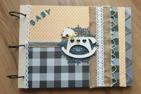 Oto przykład, scrapbooking co to: album na zdjęcia z motywem konika na biegunach i napisem "BABY".