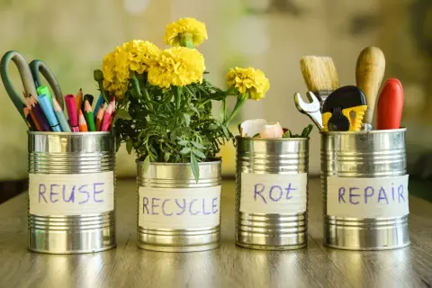 Puszki metalowe pokazują, co zrobić z odpadami: REUSE (nożyczki, kredki), RECYCLE (kwiaty), ROT (skorupki jajek), REPAIR (narzędzia).
