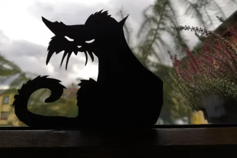 Czarny, papierowy kot, idealny jako ozdoby na Halloween zrób to sam. Jego groźny wygląd dodaje klimatu.