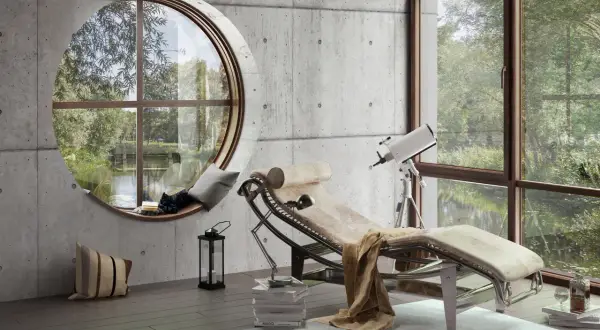 Nowoczesny salon z betonem i drewnem. Leżanka, teleskop i okrągłe okno z widokiem na zieleń.