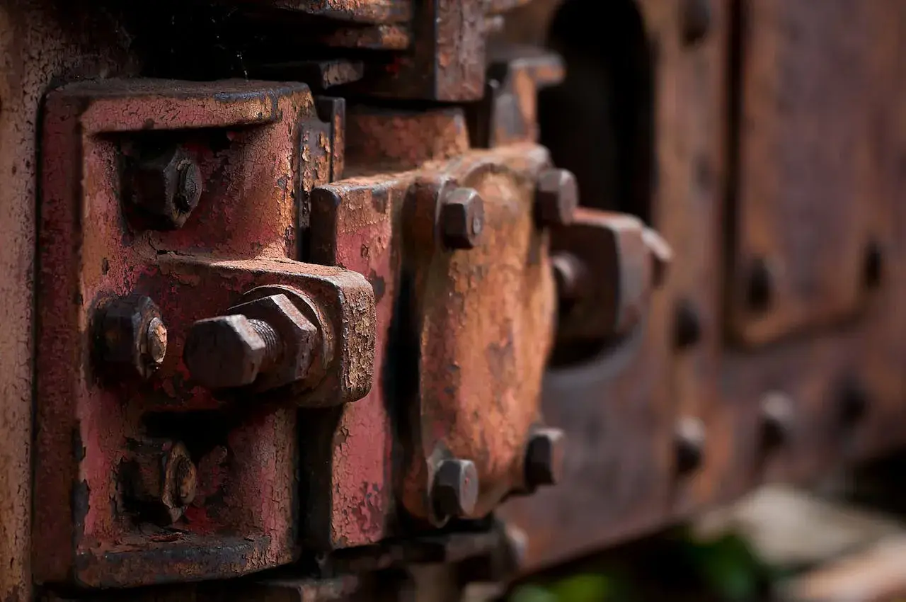 Zardzewiałe śruby i elementy maszyn, które pokazują, jak usunąć rdzę z metalu.