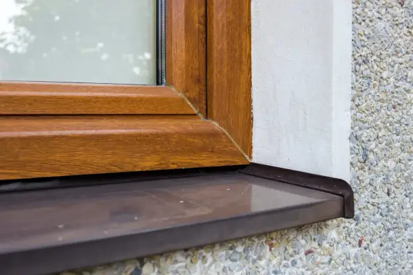 Zastanawiasz się, czym pomalować parapet zewnętrzny z blachy ocynkowanej? Ten brązowy parapet przy drewnianej ramie okna wygląda świetnie.